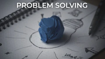 Problem solving concept with a crumpled blue paper ball placed on a notebook sketch of a lightbulb, symbolising creativity, innovation, and idea generation.