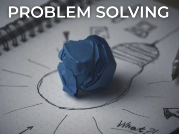 2 Problem solving concept with a crumpled blue paper ball placed on a notebook sketch of a lightbulb, symbolising creativity, innovation, and idea generation.