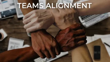 Team alignment concept with four diverse hands interlocked in unity, symbolising collaboration, trust, and cohesion in a professional workspace.